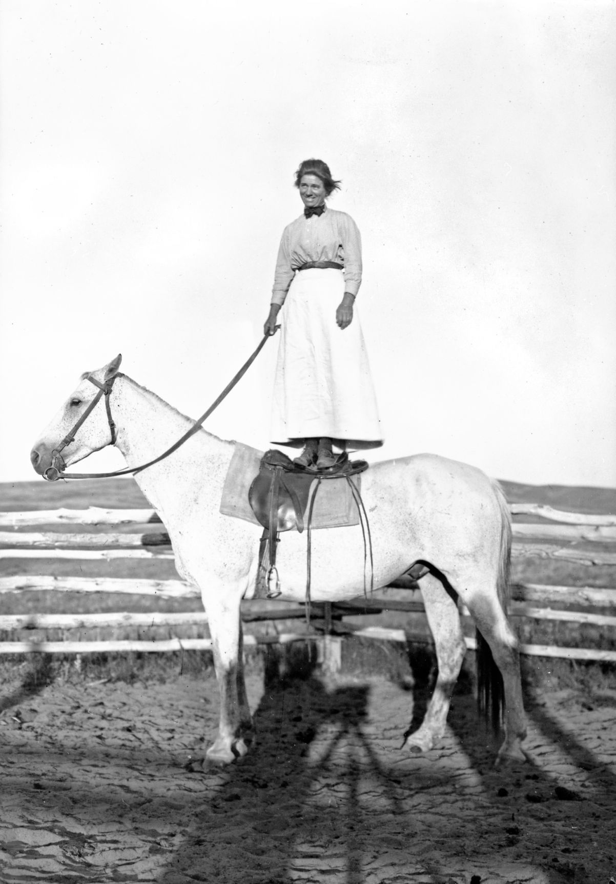 Evelyn Cameron standing on Jim the horse.